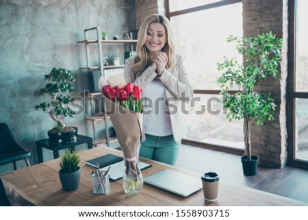 So cute! Photo of beautiful blond business lady came workplace looking affectionate fresh tulips bunch little postcard on table corporate unexpected 8 march surprise in office