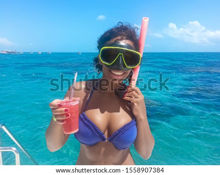 Woman holding drink having fun with snorkel on a beautiful  day in Natal - Rio Grande do Norte - Brazil. 