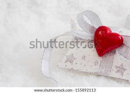 Close up of white and silver present box with red hearts