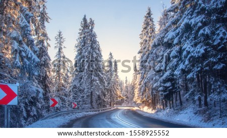 Scenic winter. Snowy forest and road. Christmas background. Beautiful countryside nature landscape. Wintry highway