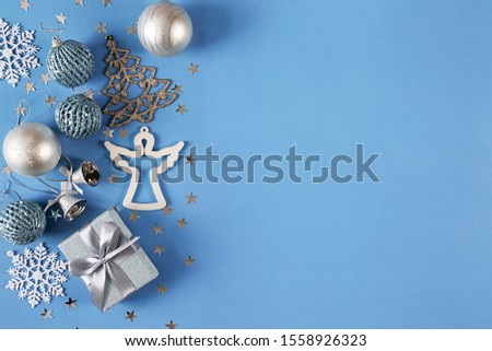 Christmas banner with silver toys, decorations and gift on blue background. Greeting card, template, layout. Winter holiday. Happy New Year. Copy space. Top view. Flat lay.