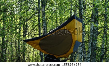 Inverted tent on background of a beautiful spring green young forest. Spring and Hiking with tent