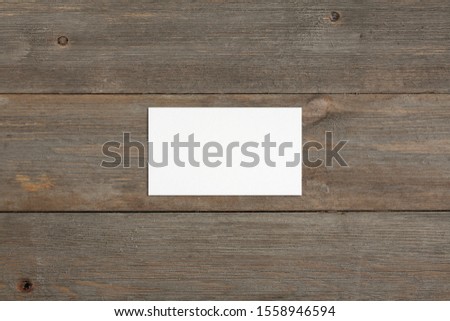 Standard empty white business card mockup on brown rustic wooden background. Flat lay, top view. For branding identity, logo design pitches and marketing.