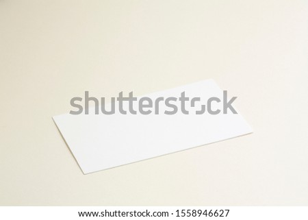 Standard empty white business card mockup on bone coloured background perspective angle. For branding identity, logo design pitches and marketing.