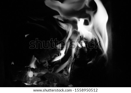 Black and white picture of a fireplace. Big flames and burning hot.