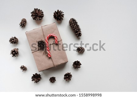 Christmas composition. Christmas gift with Christmas Candy Cane, pine cones on white background. Top view, flat lay, copy space. Christmas composition of pine cones