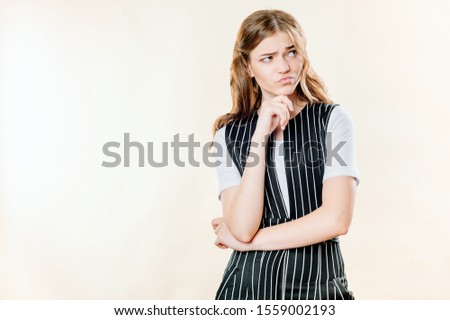 portrait of a pensive and sullen girl on a light background, a sullen frown