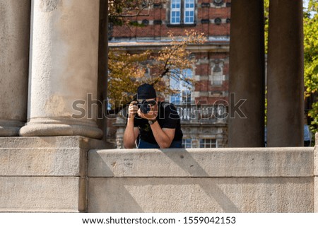 Young photographer in sunglasses and a baseball cap.