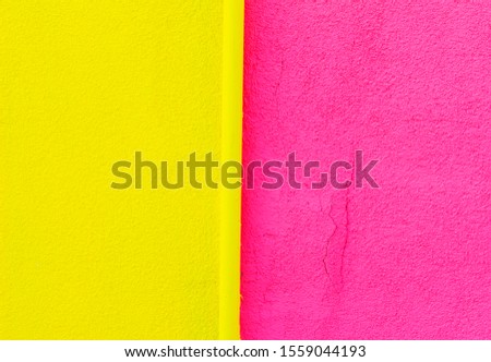 a wall of old home in Turkey painted to yellow and pink . colorful rough surface.