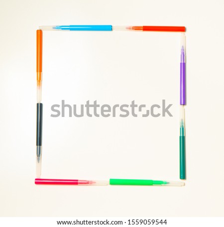 Colorful felt-tip pens on the white background. Markers pattern in the shape of square. Background or texture. Place for text.