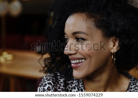 Portrait of beautiful African American girl with coffee. Close up portrait of beautiful young black woman smiling. Happy cheerful beautiful african girl in leopard print dress smiling looking at camer Royalty-Free Stock Photo #1559074229