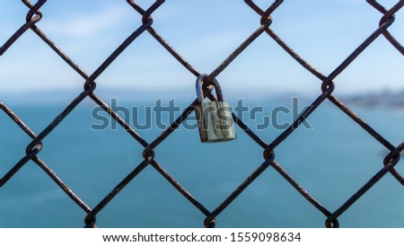 San Francisco, USA - August 2019: Shiny metal padlock on a fence symbolizing love and commitment