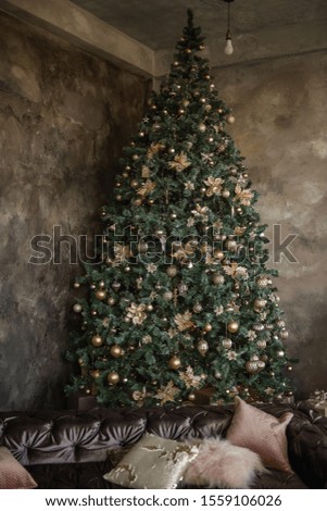 Magic Christmas card. Textured dark loft with a large green Christmas tree, fashionable toys, decorations, garlands. Presents lie by the old vintage fireplace. Cozy chalet. Copy space, place for text