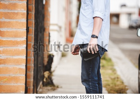 A closeup shot of a male standing on the sidewalk while holding the bible with a blurred background