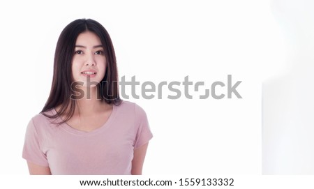 An Asian woman wearing a pink shirt, standing comfortably on a white background. There are a copyspace and isolating.