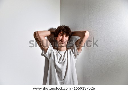 portrait of expressive handsome attractive young teenager Italian model boy posing and gesturing for casual shooting wearing a t-shirt. white background