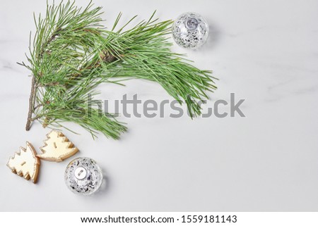 new year concept. green pine branch and Christmas decorations on marble background. flat lay, copy space.