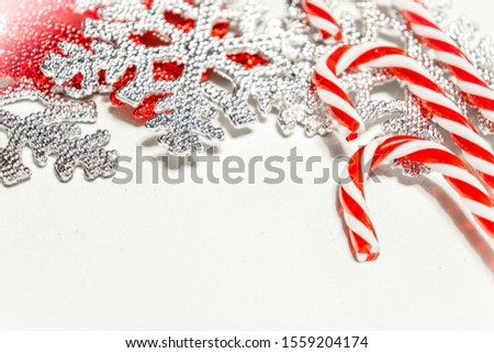 Christmas design with candy canes and silver / red snowflakes. Empty space for text. Selective focus. 