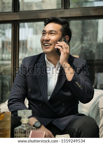 Rich businessman in real estate concept in cafe with smart phone.