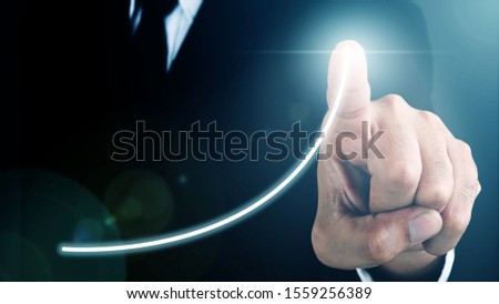 Man standing and pointing hand with Line Visual Graphic on Light of Len flare and Bokeh blue background. COPY SPACE. Business Concept : Market Uptrend.