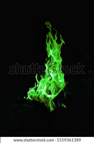 Green flames with dark background.fire green flames on a black background. Royalty-Free Stock Photo #1559361389