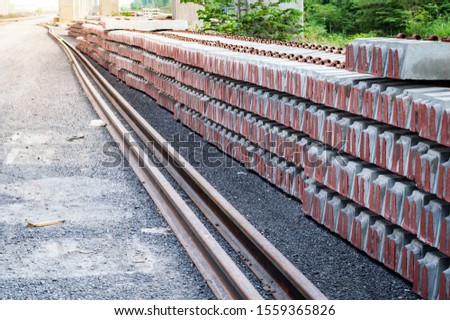Background and Texture of piled concrete sleeper at train station.Pile of precast concrete sleepers ready for construction in trackwork.Sleepers made of concrete laid in a row for rails.
