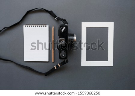 Work office desk with notepad, pencil, photo camera and frame