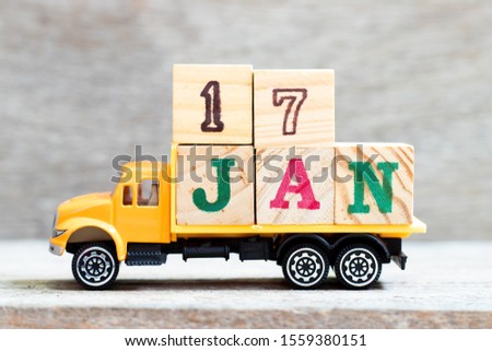 Truck hold letter block in word 17jan on wood background (Concept for date 17 month January)