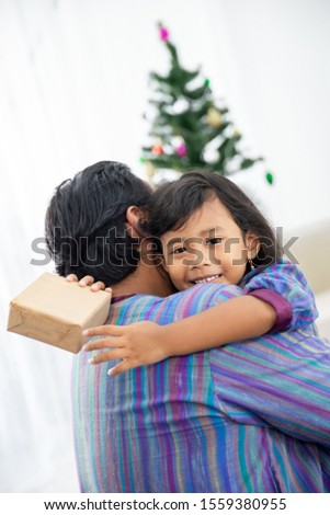 portrait of asian family. father and daughter embrace and kiss each other in christmas day