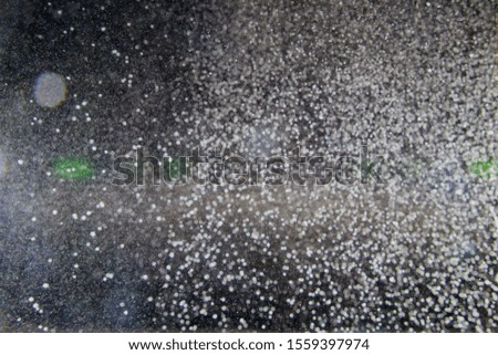 Abstract white blurred dust explosion and flash with illumination on a black background