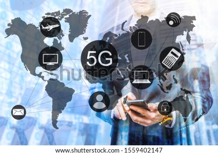 The double exposure image of the business man using a smartphone during sunrise overlay with cityscape image. 5G mobile technology concept - high internet speed