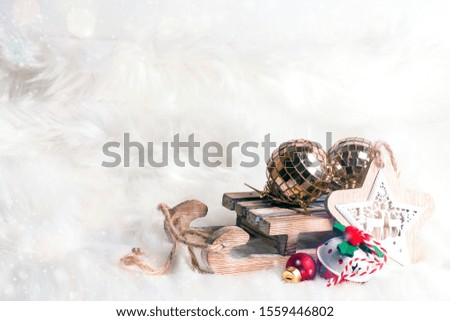 Wooden toy sled with festive decorations over fur background. Christmas and New year composition with copy space.