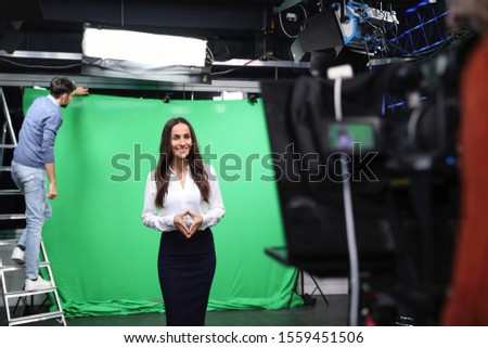 Presenter, technician and video camera operator working in studio. News broadcasting