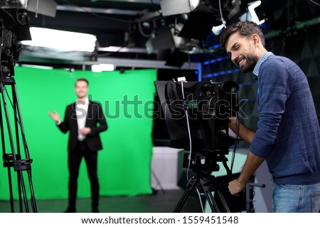 Presenter and video camera operator working in studio. News broadcasting