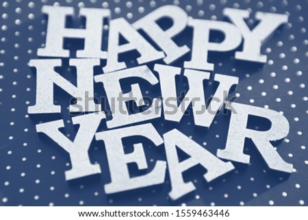 Happy New Year background.Fading blue color and white wooden letters shot in close up