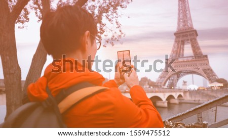 Travel tourist  which  he's a take a picture by smartphone at Eiffel tower, Paris. France
