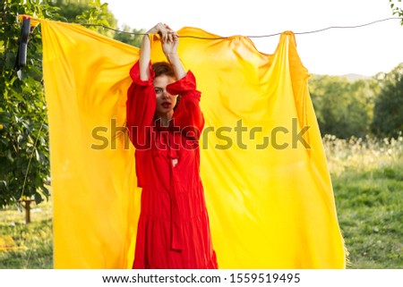 young woman in a beautiful long dress with yellow cloth on the street