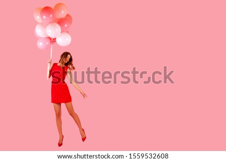 Beautiful Girl Portrait in a red dress and high-heeled shoes, a happy girl holding a bunch of balloons with one hand. color background. Attractive woman. isolated. Portrait Summer model Girl. pink    