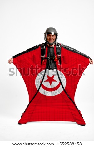 Tunisia flag travel. Bird Men in wing suit flag. Sky diving men in parashute. Patriotism, men and flag.
                               