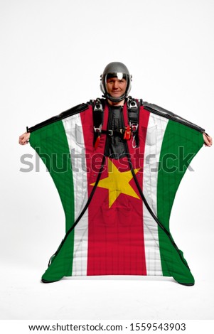Surinam flag travel. Bird Men in wing suit flag. Sky diving men in parashute. Patriotism, men and flag.
                              