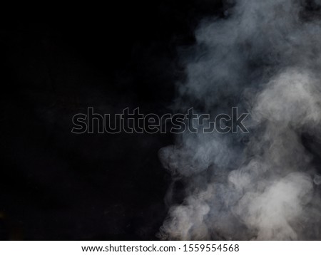 Light smoke texture on a dark background. Studio photography