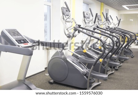 Treadmills and bikes in a fitness hall. Fitness club with row of treadmills for fitness cardio training in evening backlight. Healthy lifestyle concept.selective focus