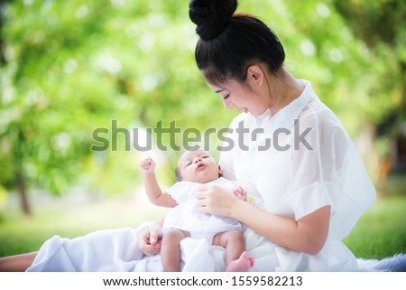 Portrait of asian mother playing with newborn baby, baby talking to mother. Health care family love together. Asian girl lifestyle. Asia mother's day concept / Selective focus