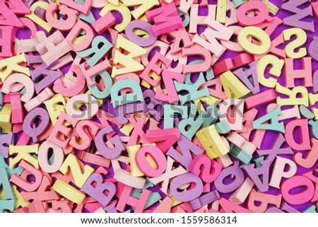 random colorful letterpress alphabet top view on purple background