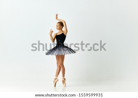 ballerina dancing on pointe and in full length tutu on isolated background