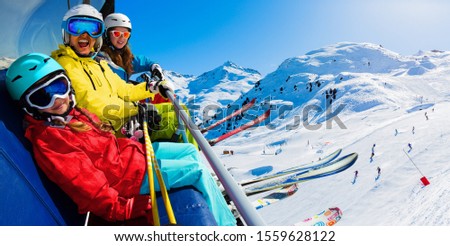 Happy family on ski lift enjoying winter vacations in mountains, Meribel, 3 Valleys, France. Playing with snow and sun in high mountains. Winter holidays. Royalty-Free Stock Photo #1559628122