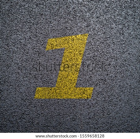 Yellow numbers and signs on the asphalt