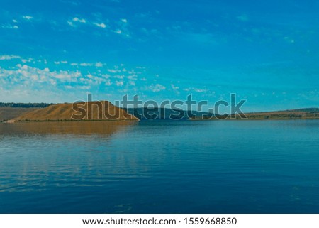 nature reservation peaceful scenery landscape panorama photography of lake smooth water surface foreground and hills open land background, summer weather clear day time, vivid blue sky, copy space 