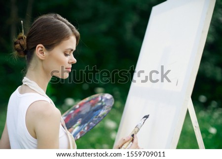 woman model paints a picture on white canvas