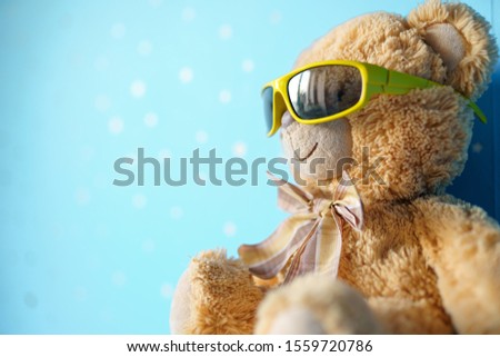 Teddy bear in sunglasses on blue background